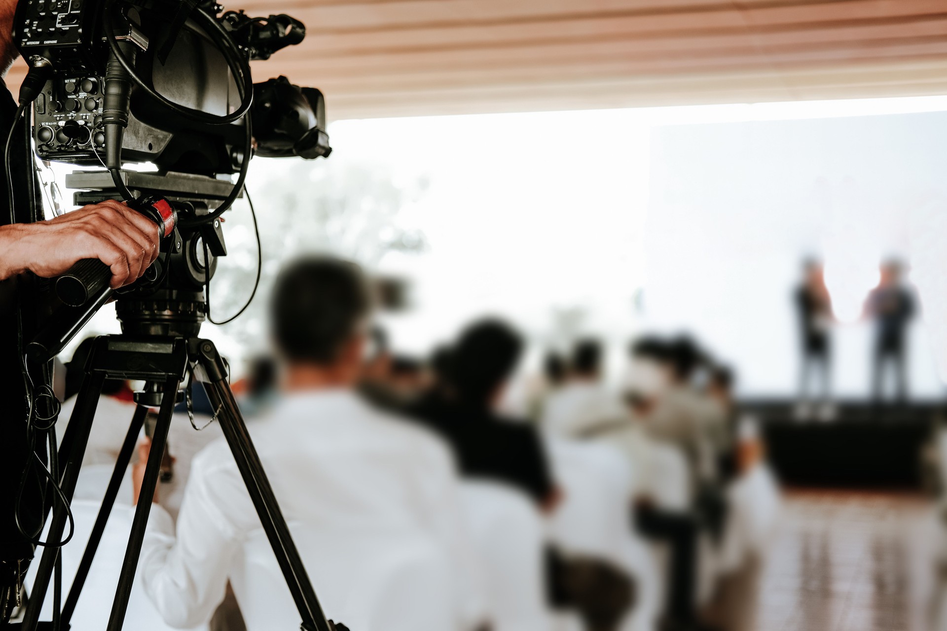 video production camera recording live event on stage. television social media broadcasting seminar conference